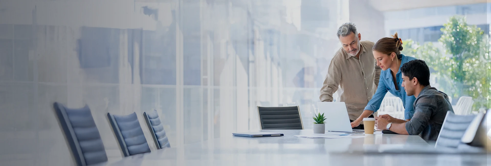 artica+i. Imagen de cabecera general para los posts de blog de la sección de actualidad de la web llamada "iMagazine" mostrando a tres personas sentadas en una mesa de oficina moderna frene a un portátil