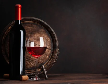 artica+i - Casos de éxito. Imagen 01 para la galería del proyecto "UHPH4WINE. Proyecto de desarrollo experimental para validar la tecnología de Ultra Alta Presión de homogeneización en la elaboración de vinos de alto valor añadido" mostrando una foto artística de una botella junto a una copa de vino, delante de un pequeño barril